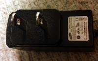 Power supply, inner side with label displaying technical ratings and regulatory certifications
